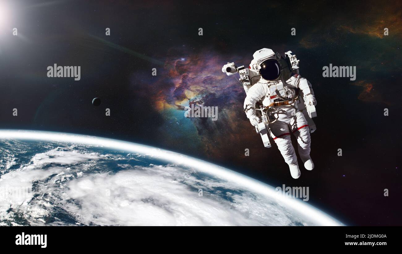 Cosmonaut in outer space against Earth planet. Elements of this image furnished by NASA. Stock Photo