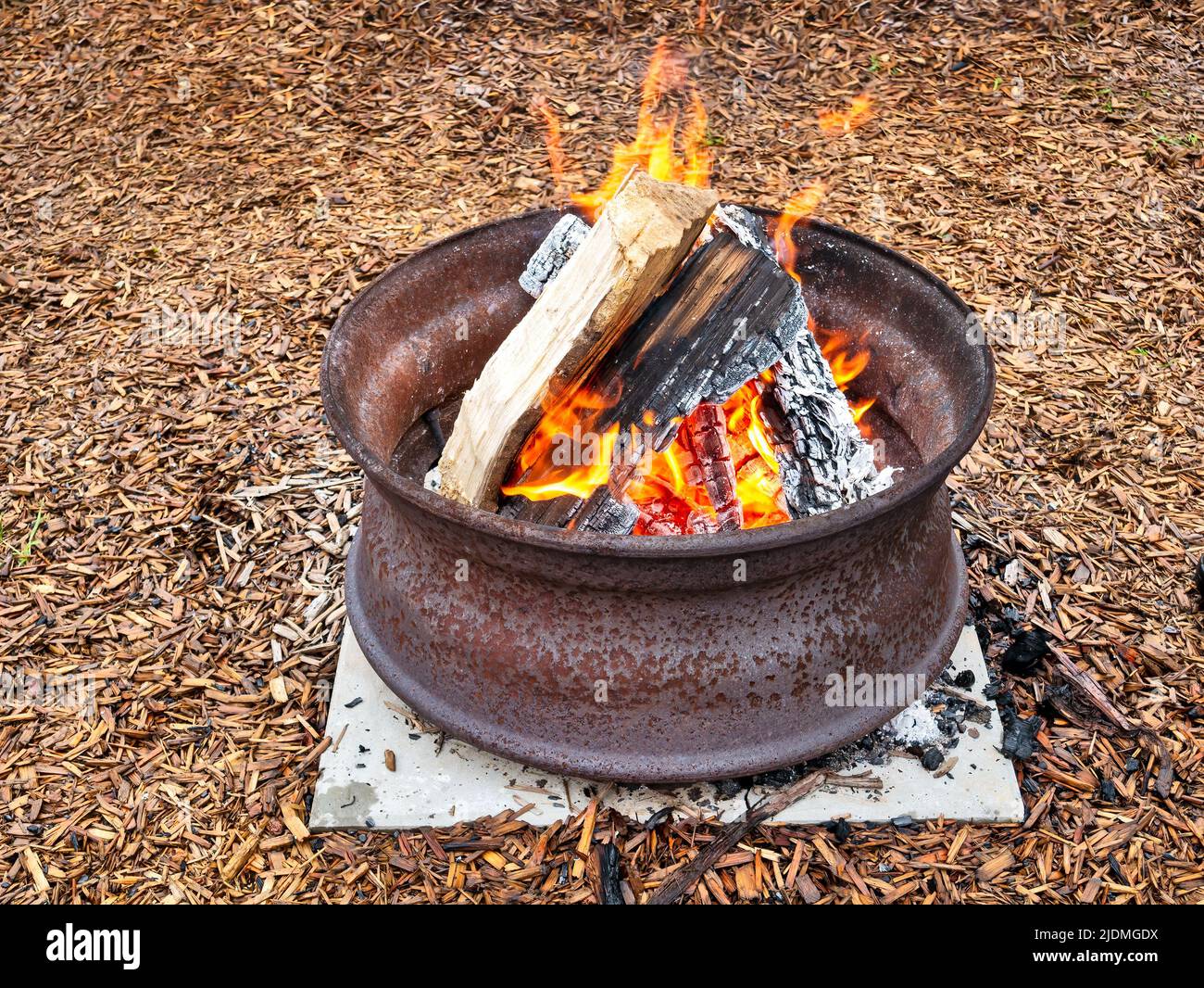 Campfire in a steel wheel on the concrete base Stock Photo Alamy