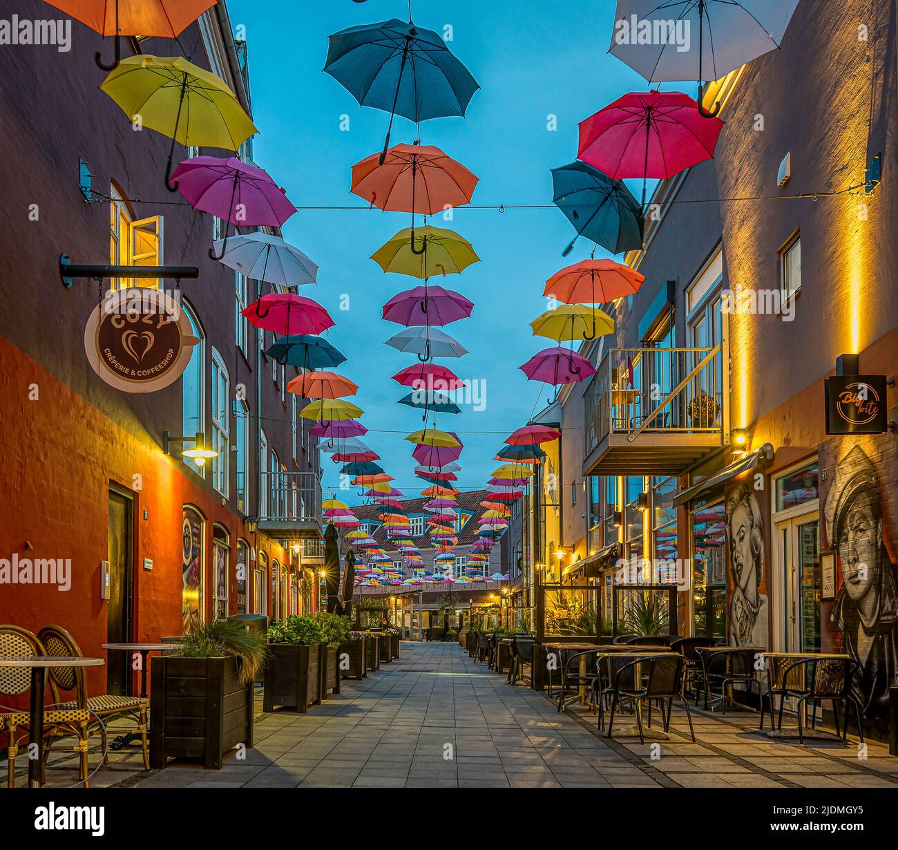 colourful umbrellas in the soft evening light over a street at the Latin Quarter in Vejle, Denmark, June 14, 2022 Stock Photo