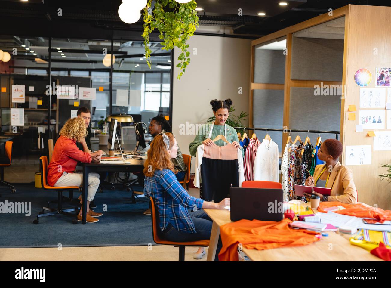 Multiracial male and female fashion designers working in office studio ...