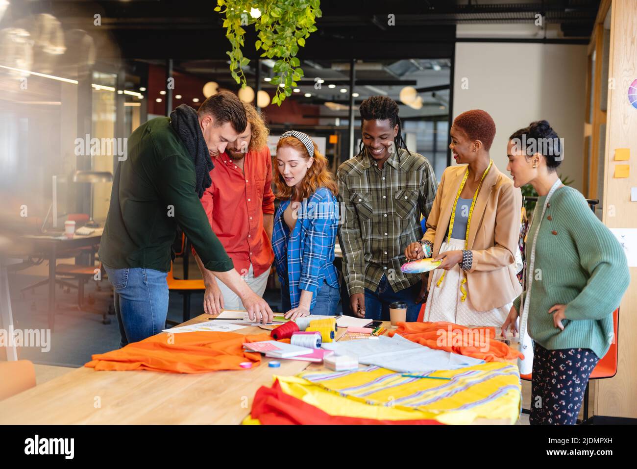 Multiracial male and female fashion designers discussing during meeting ...