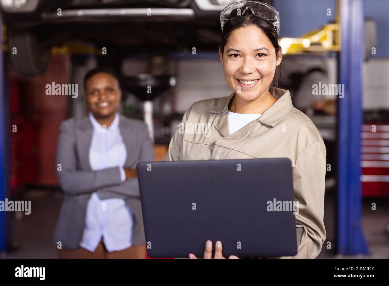 Portrait of confident smiling mid adult multiracial female mechanics working, copy space Stock Photo