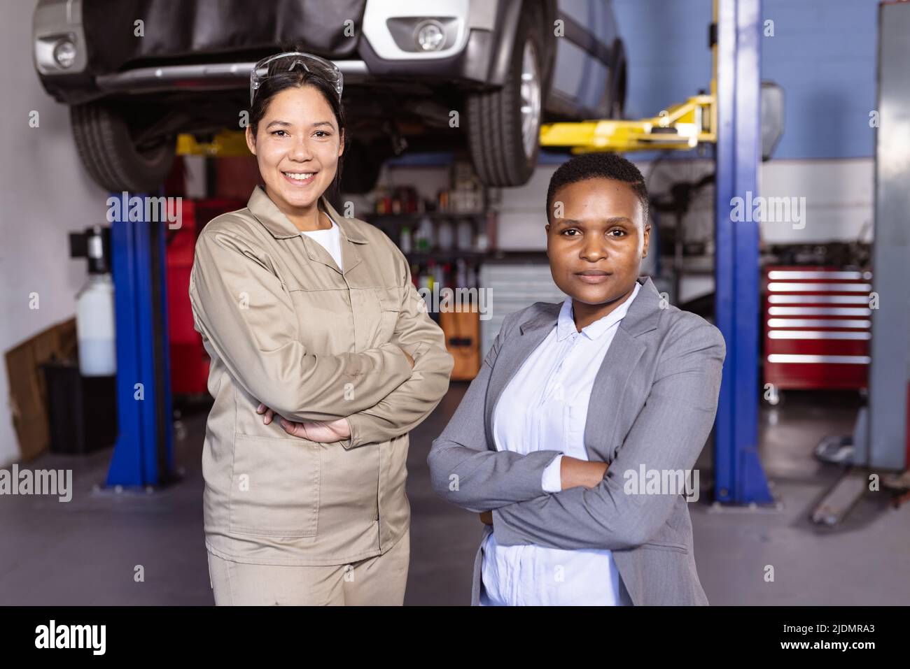 Portrait of confident multiracial mid adult female engineers with arms crossed standing in workshop Stock Photo