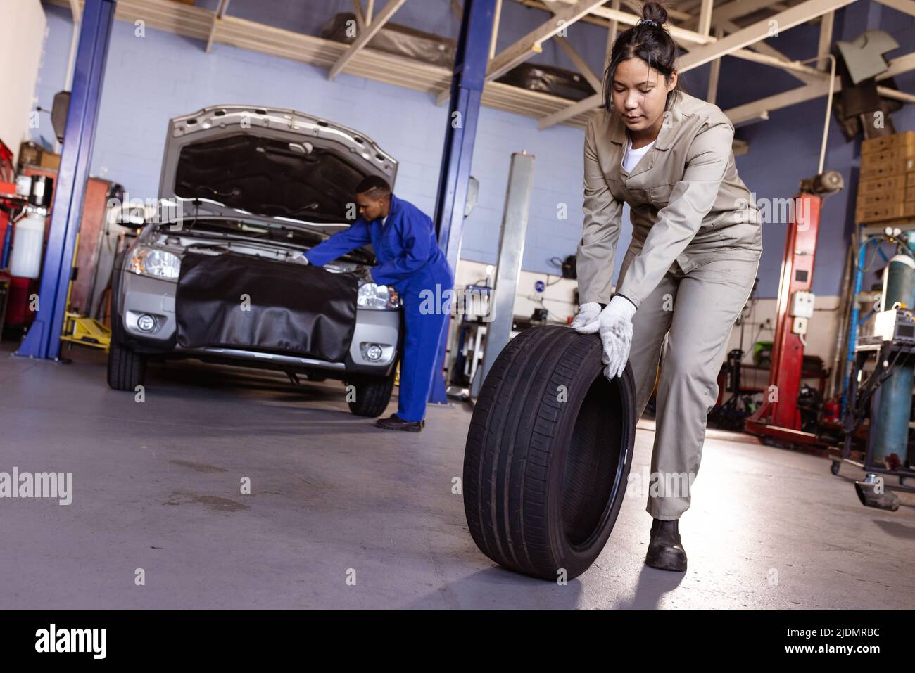 Multiracial mid adult female mechanics working in workshop, copy space Stock Photo