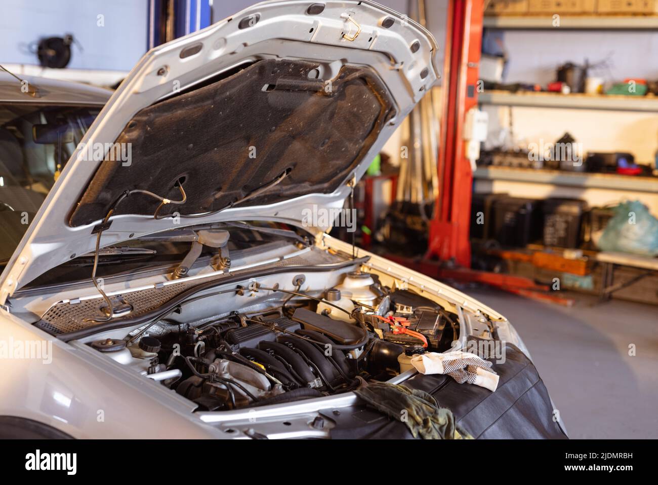 Faulty car with open bonnet in repair workshop, copy space Stock Photo