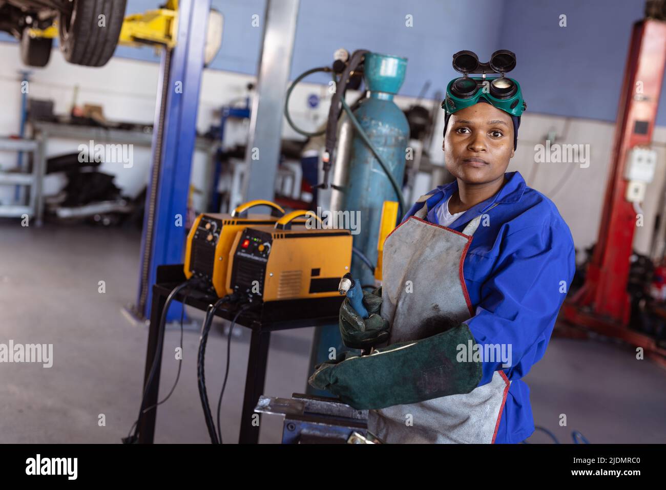 Portrait of confident mid adult african american female welder working in workshop, copy space Stock Photo