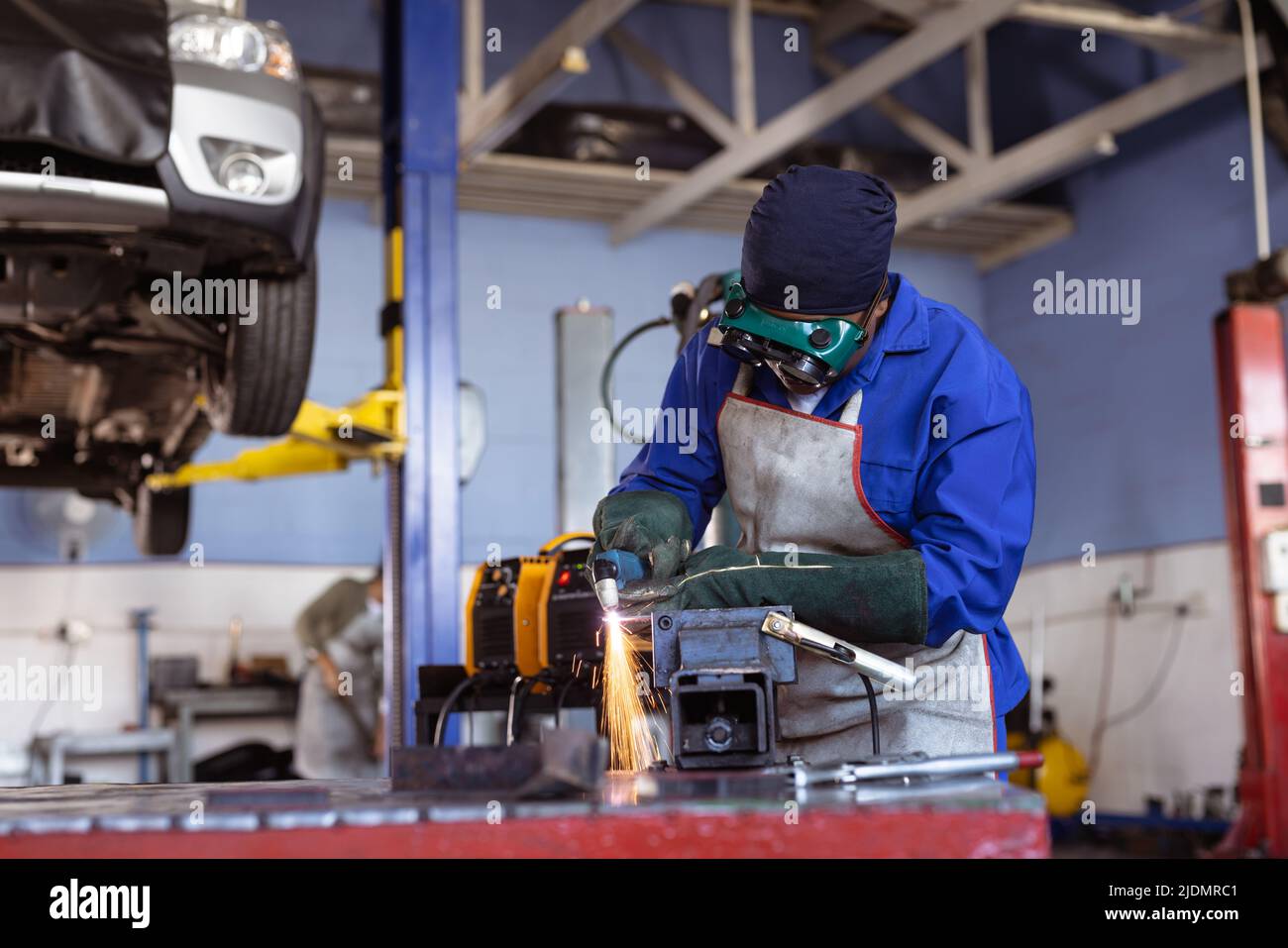 Mid adult african american female welder wearing protective workwear while wielding in workshop Stock Photo