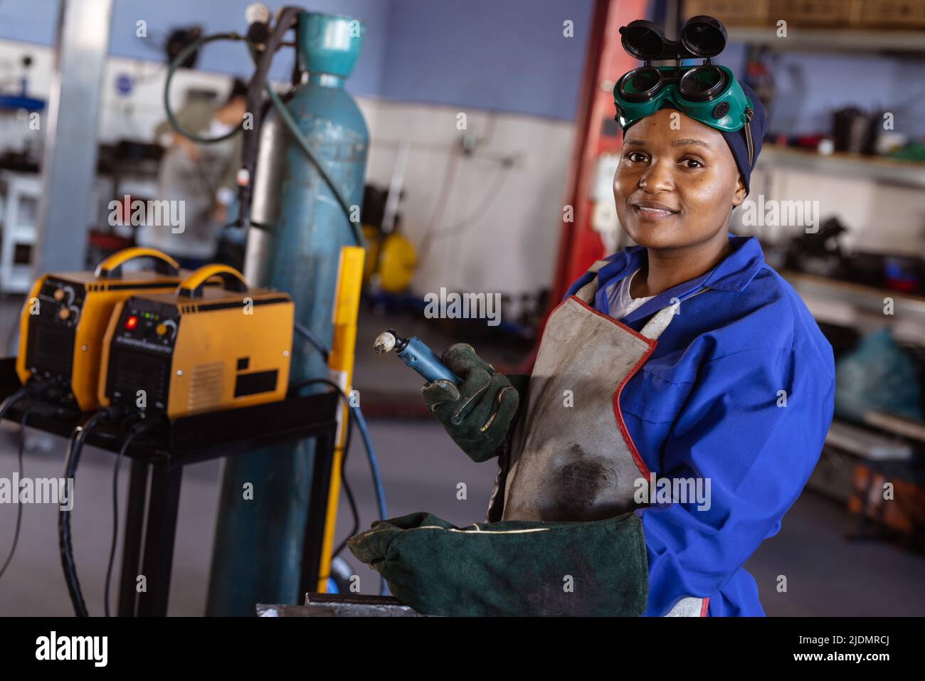 Portrait of confident smiling mid adult african american female welder working in workshop Stock Photo