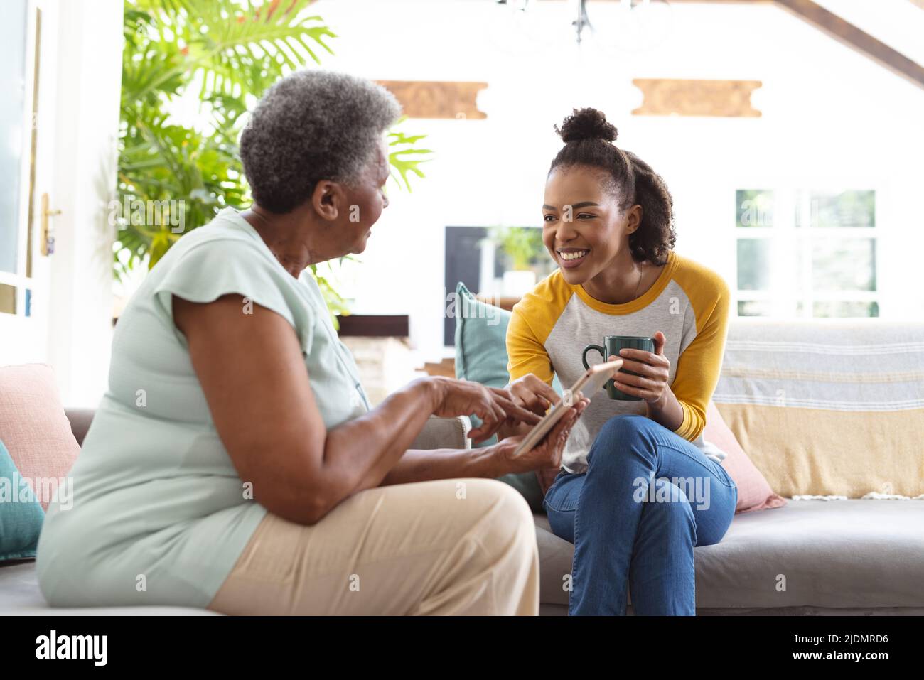 African american senior woman pointing at digital pc while showing to ...