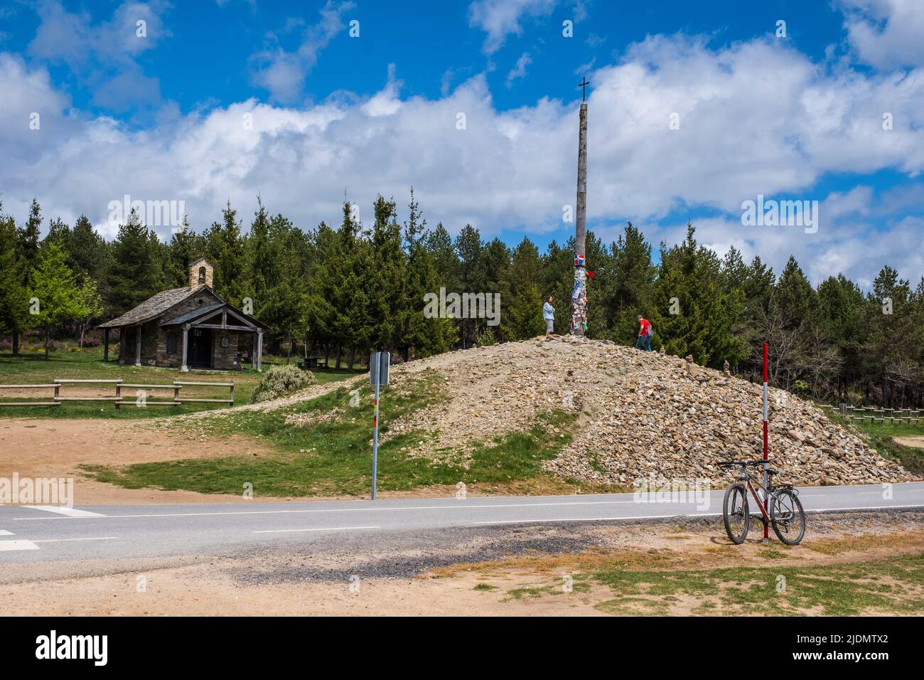 Spain, Camino de Santiago. Cruz de Ferro (Iron Cross) on Mount (Monte) Irago, highest point on the Camino de Santiago. Pilgrims leave a stone on the m Stock Photo