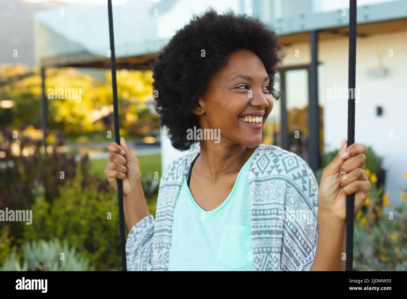 Afro young african american woman smiling while looking away outside ...