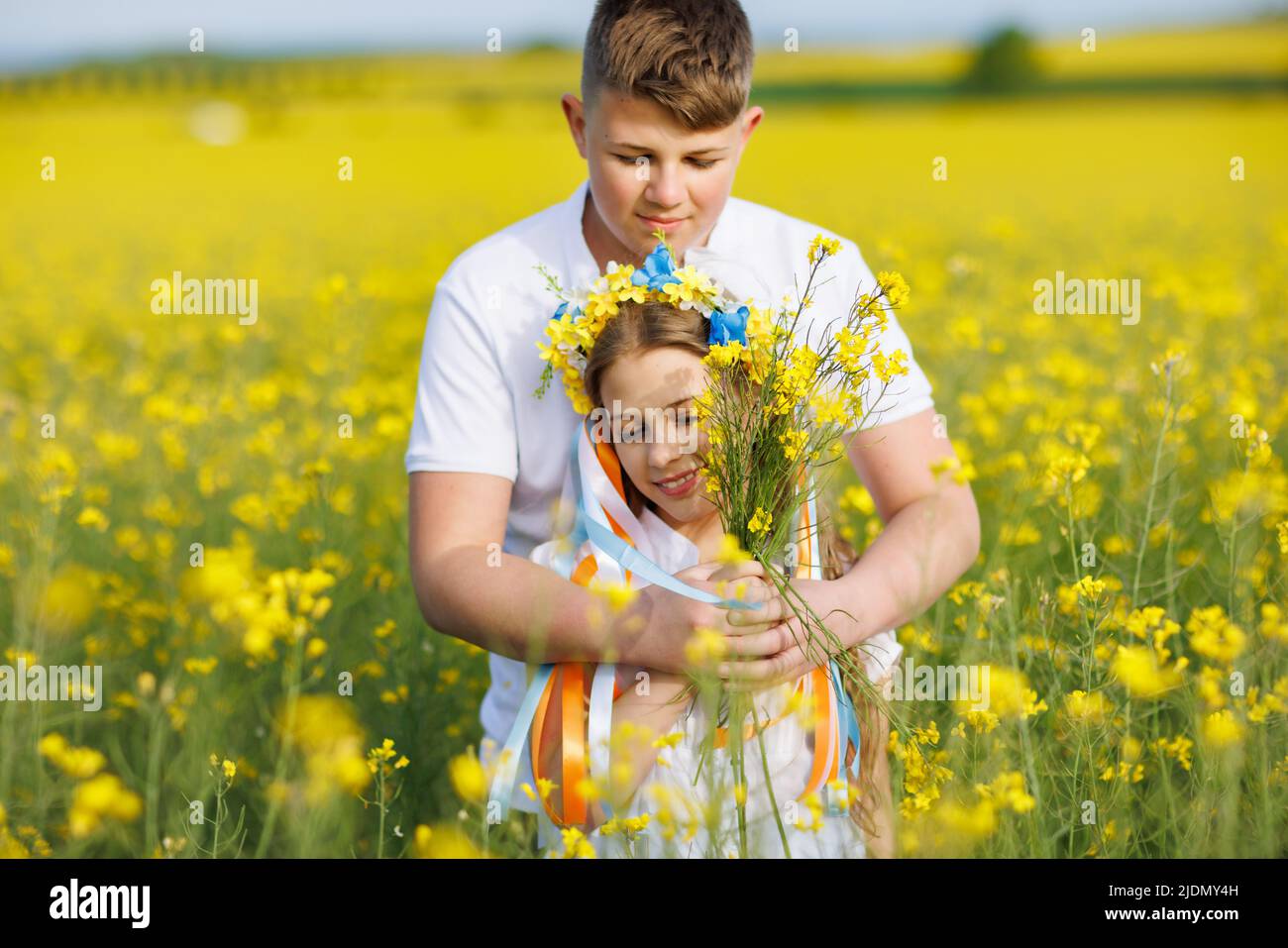 Front view of children: brother and sister walking far away along path ...