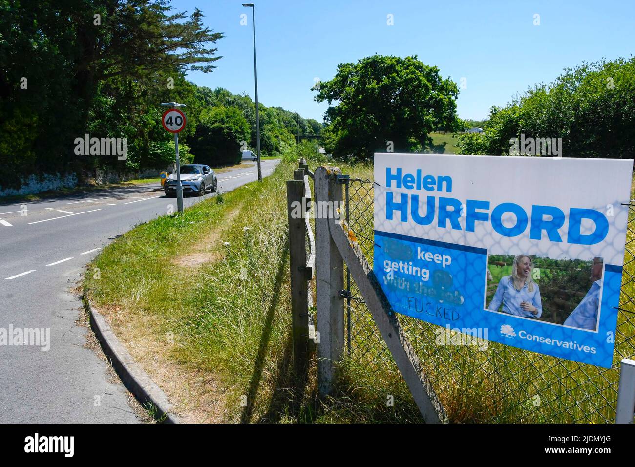 Axminster, Devon, UK.  22nd June 2022.  Election poster which has been defaced with a rude word to change the meaning of the slogan for the Conservatives candidate Helen Hurford at Axminster in Devon ahead of tomorrows parliamentary election for the Tiverton and Honiton constituency.  Picture Credit: Graham Hunt/Alamy Live News Stock Photo