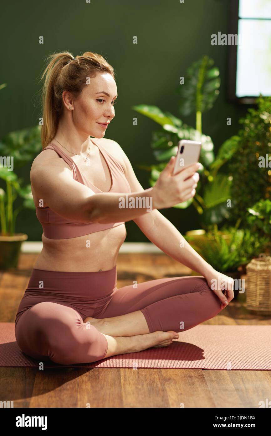 modern woman taking selfie with smartphone in the modern green house. Stock Photo