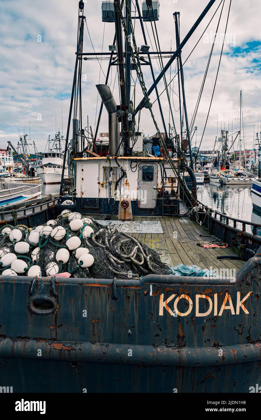 An aging fishing boat with nets sits in a marina on Kodiak island, Alaska, USA Stock Photo