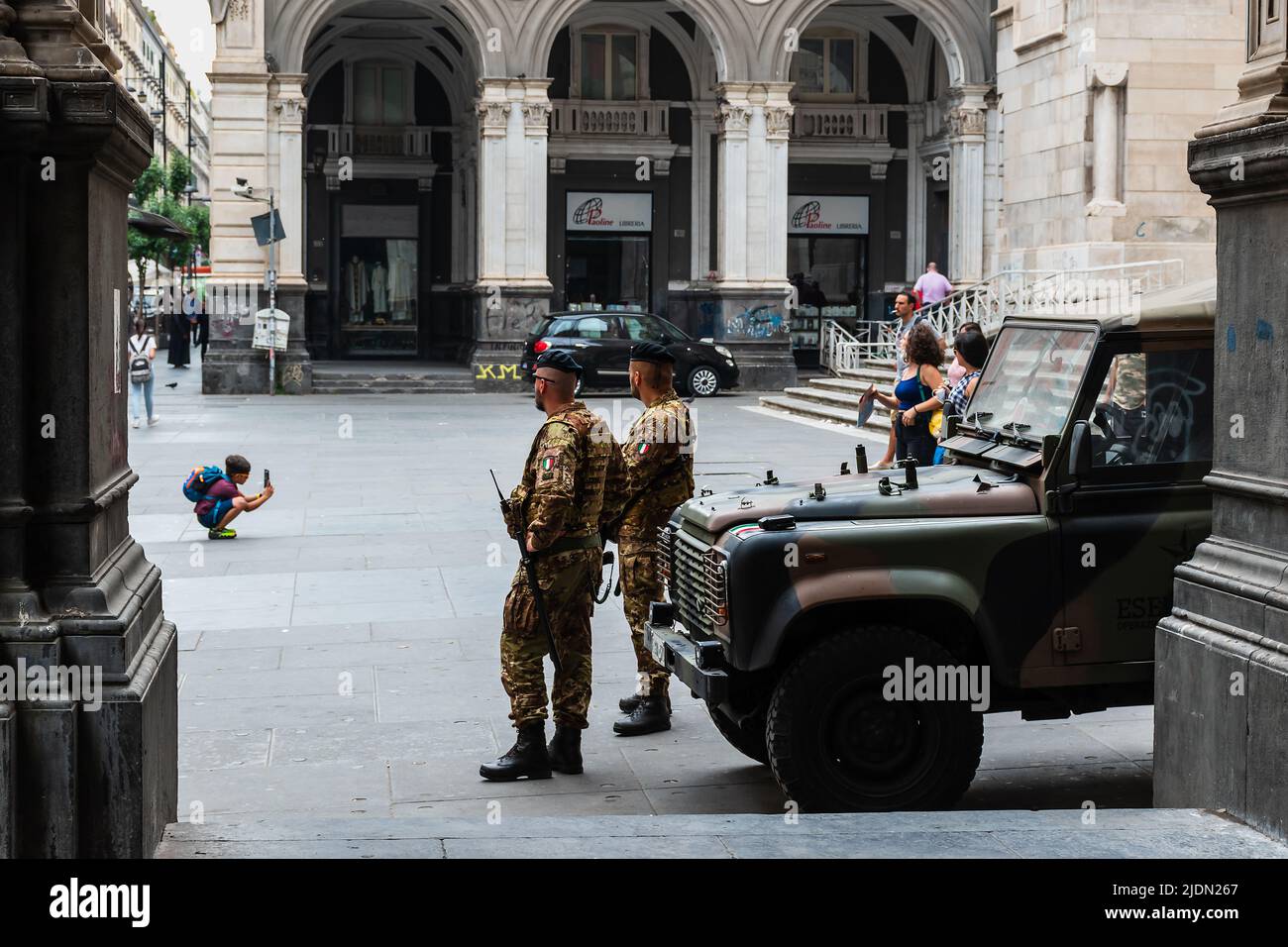 Naples, Italy. May 27, 2022. Two soldiers, a military vehicle and a kid taking a photograph on the square in front of The Naples Cathedral (Duomo di N Stock Photo