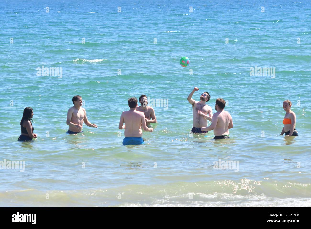 Bournemouth, Dorset, UK, 22nd June 2022, Weather. Hot afternoon in glorious summer sunshine. Mixed young people playing ball in the sea. Credit: Paul Biggins/Alamy Live News Stock Photo
