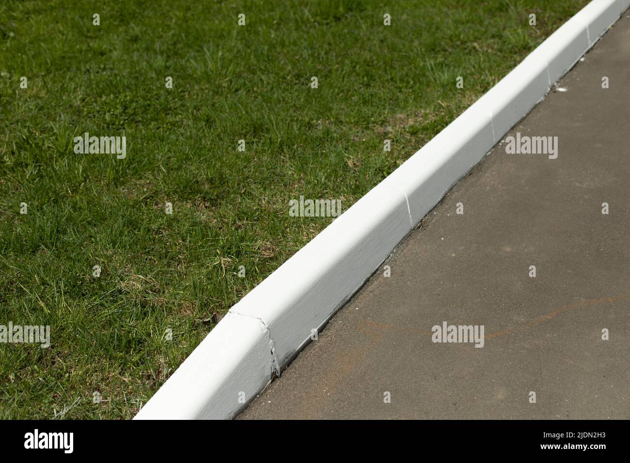 White curb on road. Landscaping in park. Painted curb Stock Photo Alamy