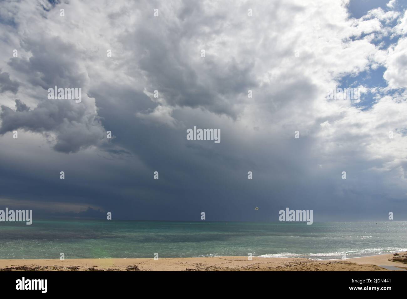 Stormy clouds over a sandy beach of Salento in Italy. Stock Photo