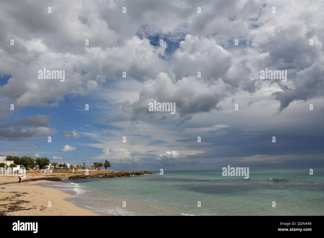 Stormy clouds over a sandy beach of Salento in Italy. Stock Photo