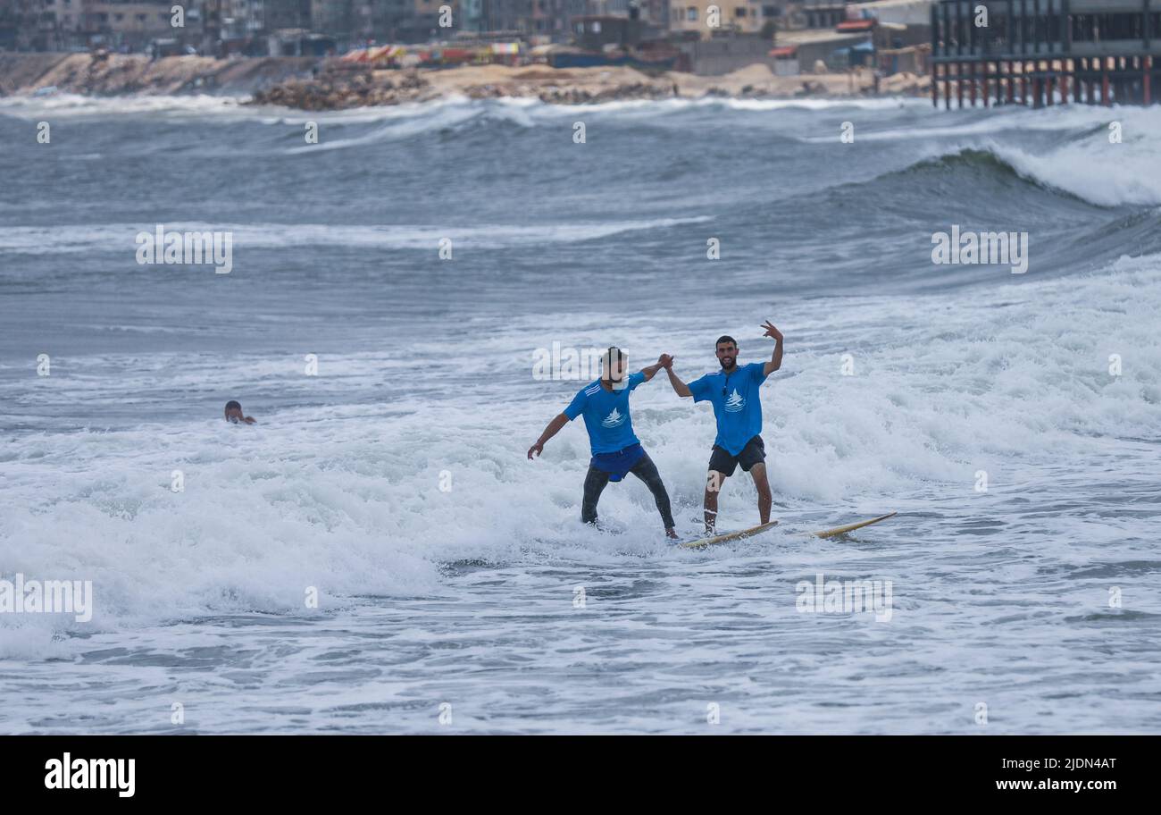 Palestinian Athletes surf on the waves during a surfing championship on