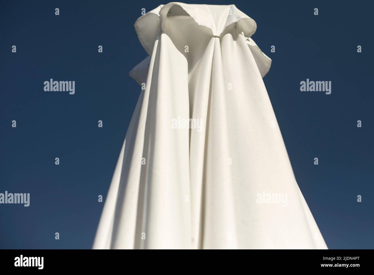 White umbrella on veranda. Sun protection. Stock Photo