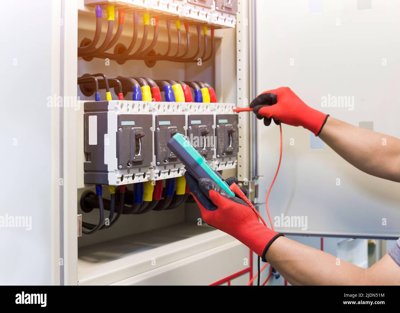 Electrical engineers check electrical control devices with a multimeter. Stock Photo