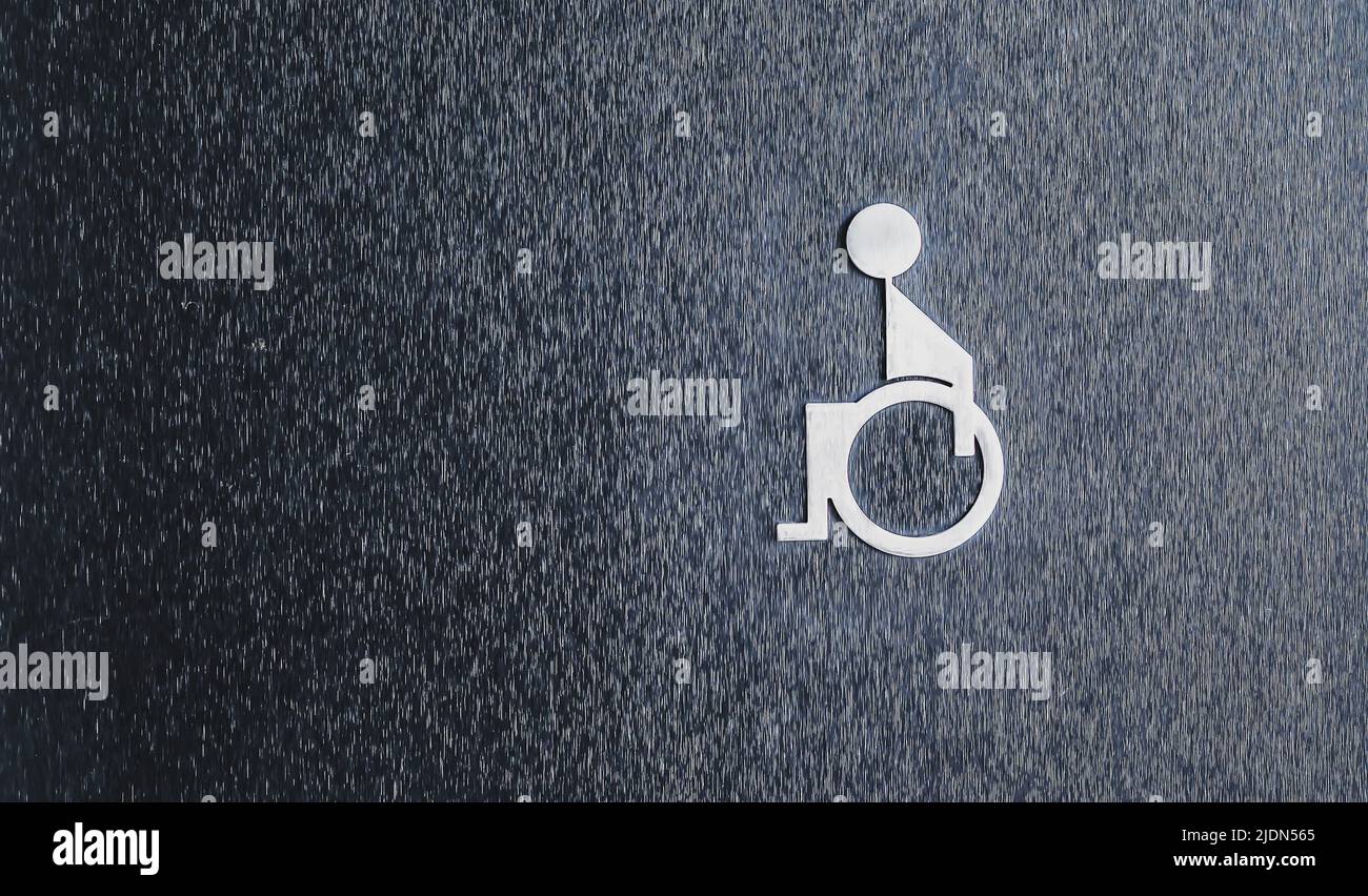 The symbol of the disabled toilet on the black wall Stock Photo