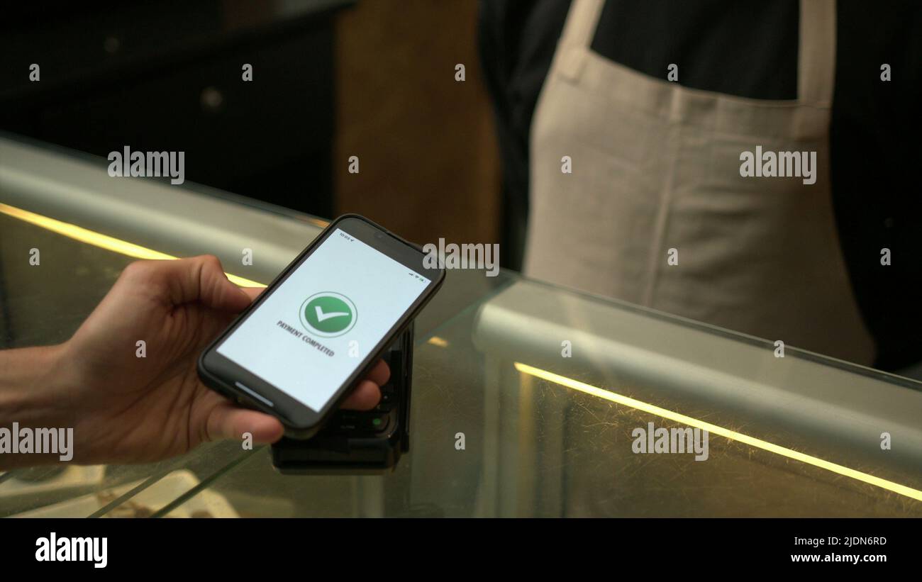 Inside Contactless Customer paying with contactless NFC payment technology on smartphone ...