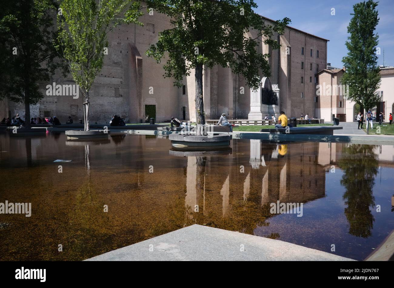 Parma, Italy - May, 2022: Fountain with trees in Piazza della Pace square in old town on site of Roman ruins of Chiesa di San Pietro Church Stock Photo