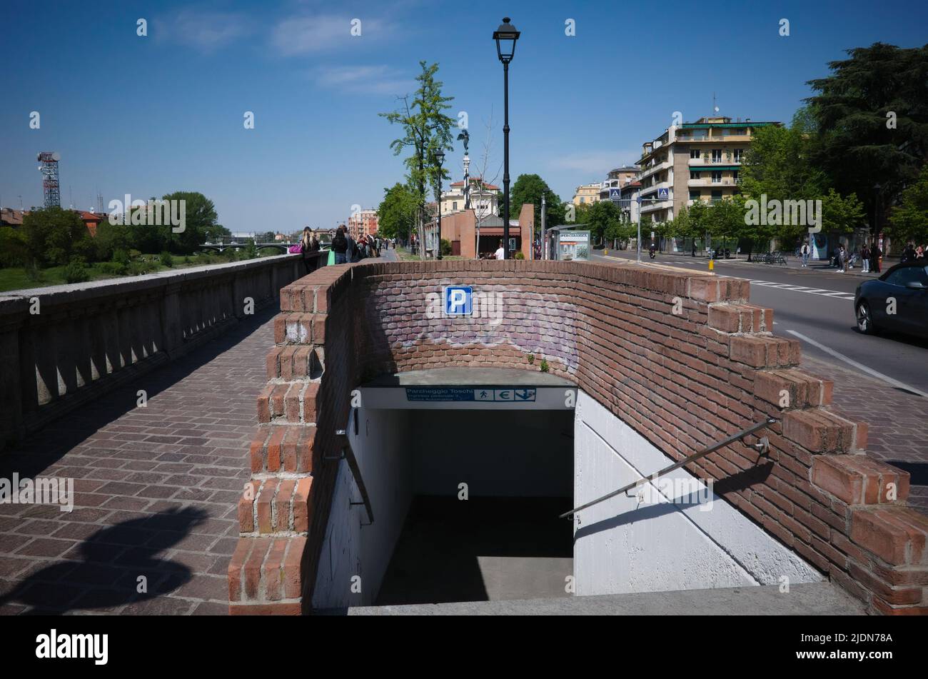 Parma, Italy - May, 2022: Entrance to underground parking and underground pedestrian crossing made of bricks on embankment on Viale Toschi street Stock Photo