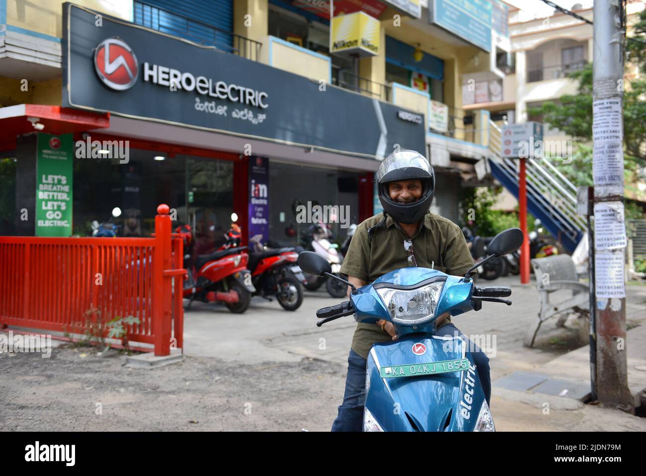 A man poses on an Electric twowheeler vehicle outside at the Hero