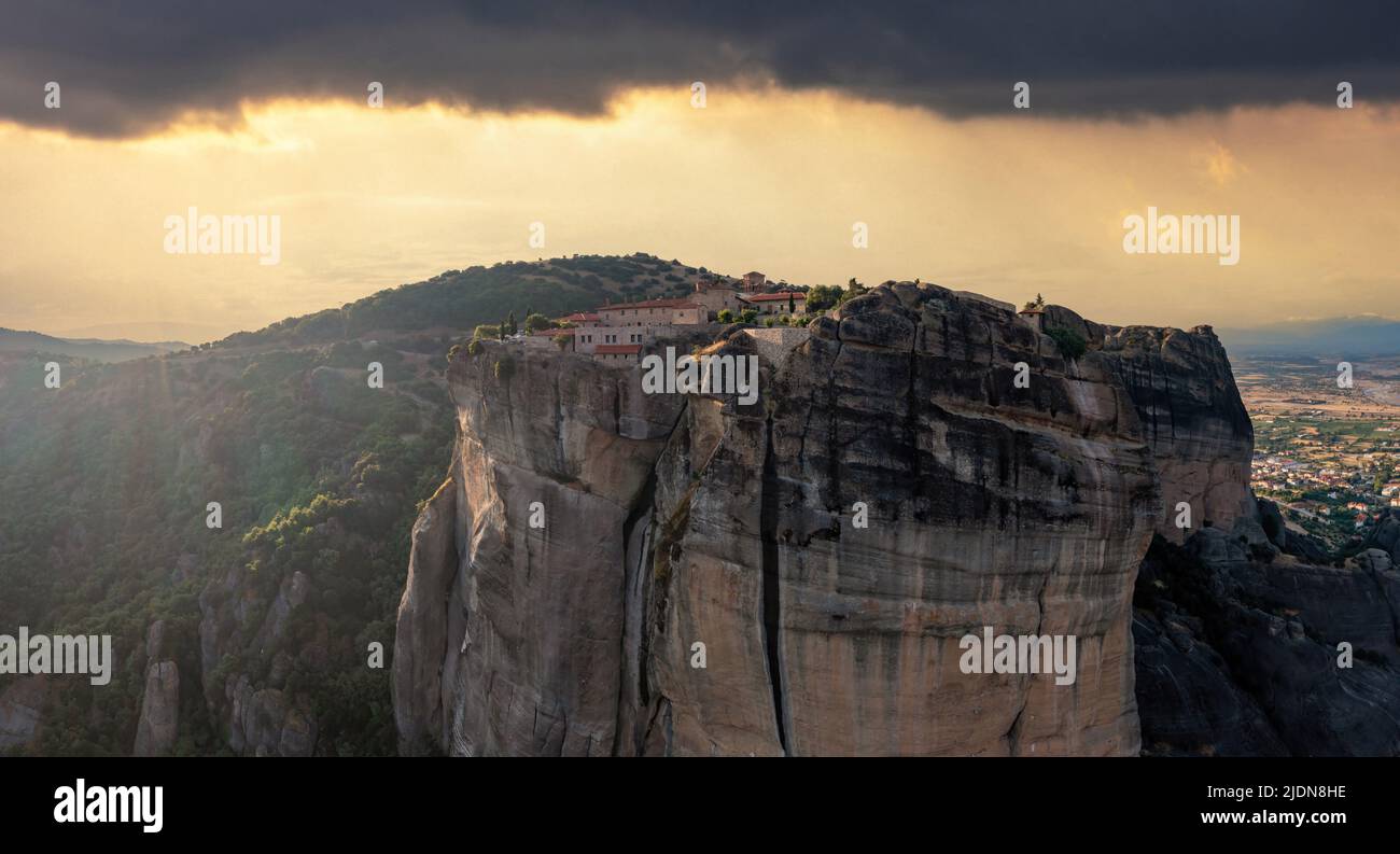 Meteora Greece Holy Trinity Monastery at sunset. Colorful sky with clouds over buildings on top of rocks. Europe travel destination Stock Photo