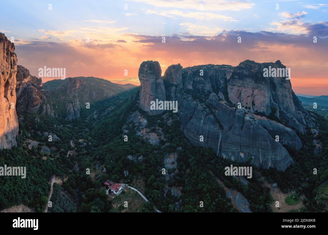 Meteora Greece rock formations at sunset. Colorful sky with clouds over rocky landscape. Europe travel destination Stock Photo