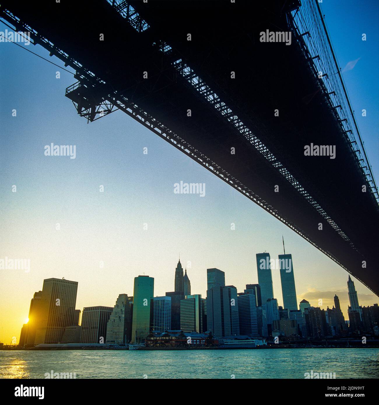 New York 1980s, Brooklyn bridge, East river, lower Manhattan skyline at sunset with WTC World Trade Center twin towers, New York City, NYC, NY, USA, Stock Photo