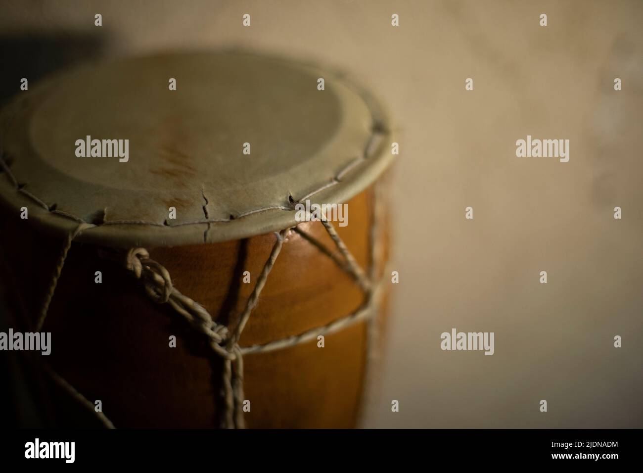 African drum. Acoustic instrument. Shock intrusion at home. Brown tree. Ropes and leather. Stock Photo