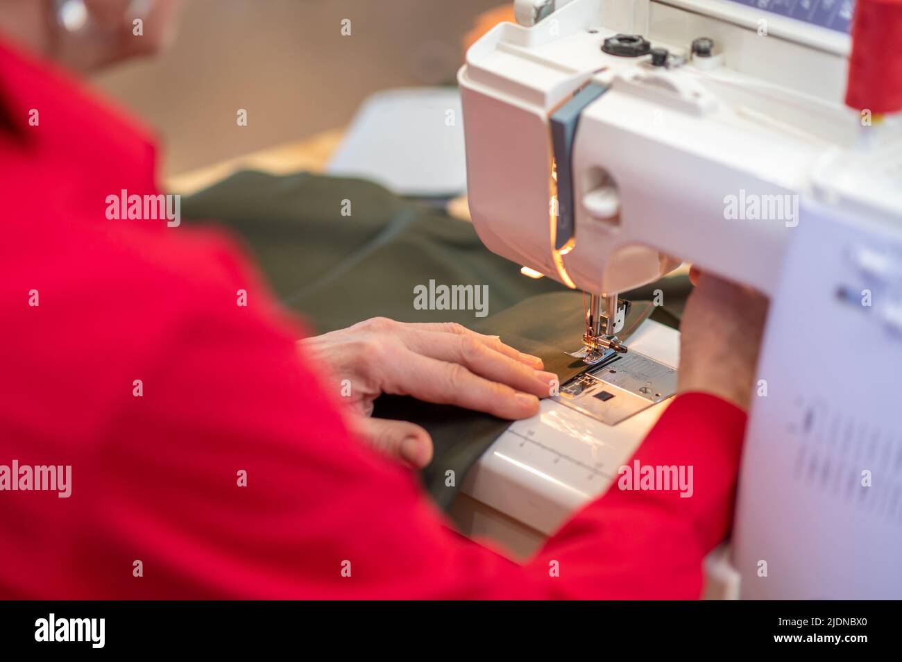 Hands making seam on fabric on sewing machine Stock Photo Alamy