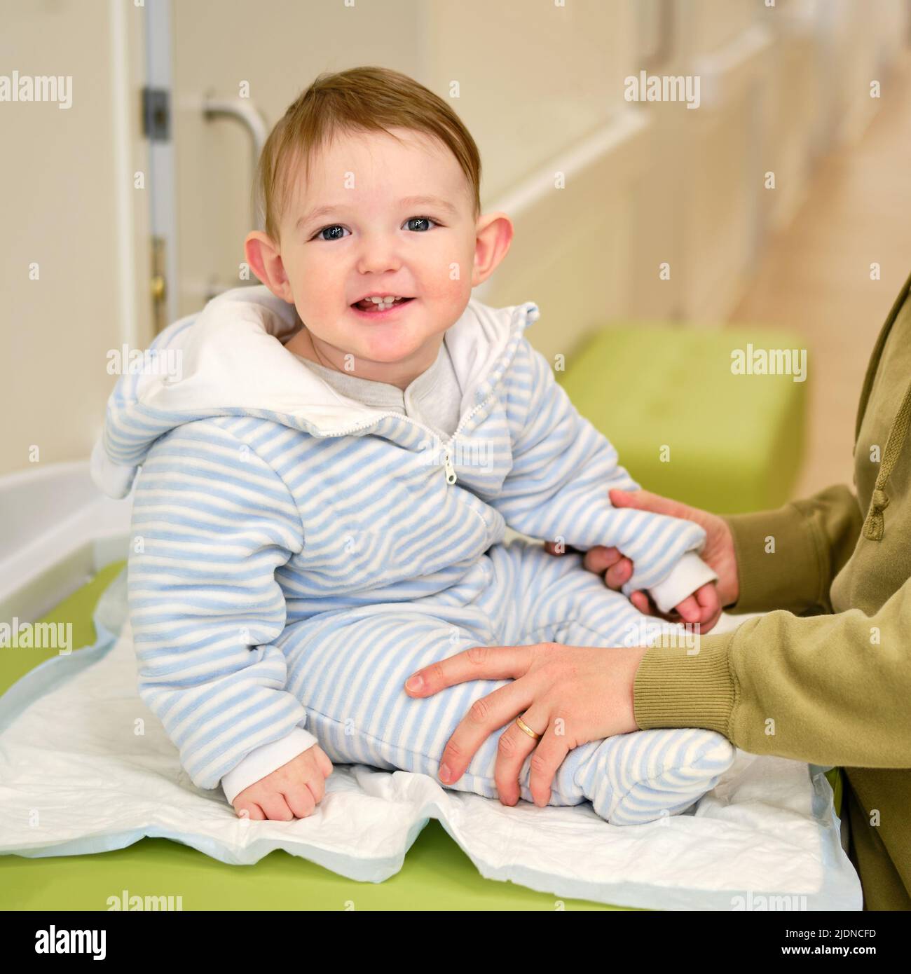 Mom with a child in the corridor of the hospital on the table for
