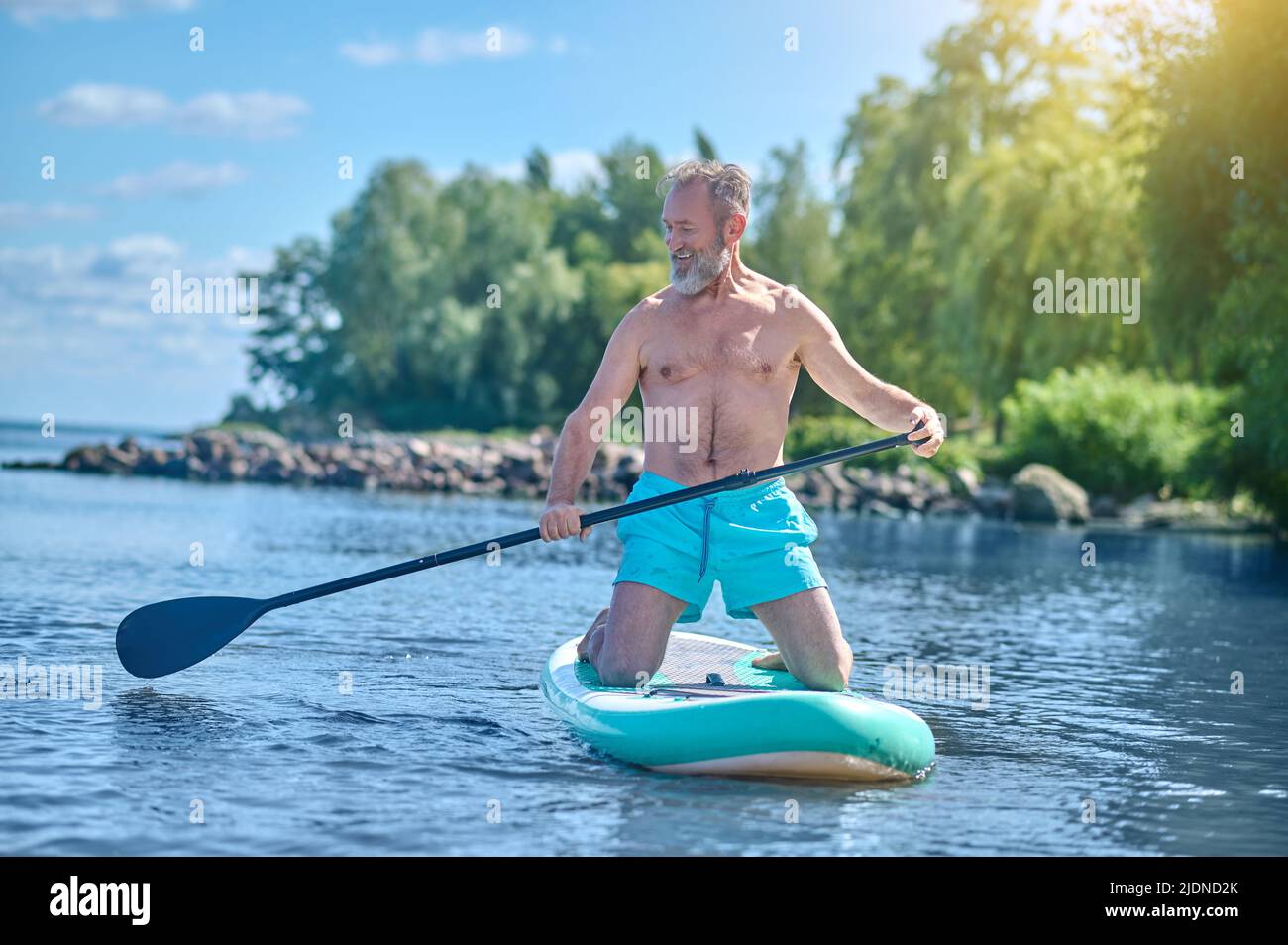 Man with oar on board gliding on water Stock Photo Alamy
