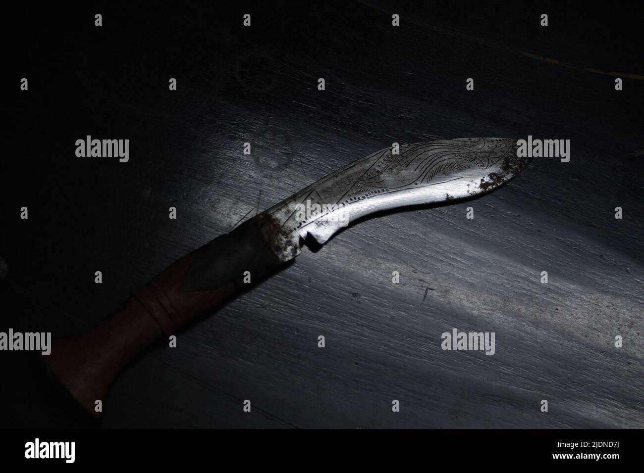 Shining Kukri knife or Nepalese machete in dramatic light, top view. Stock Photo