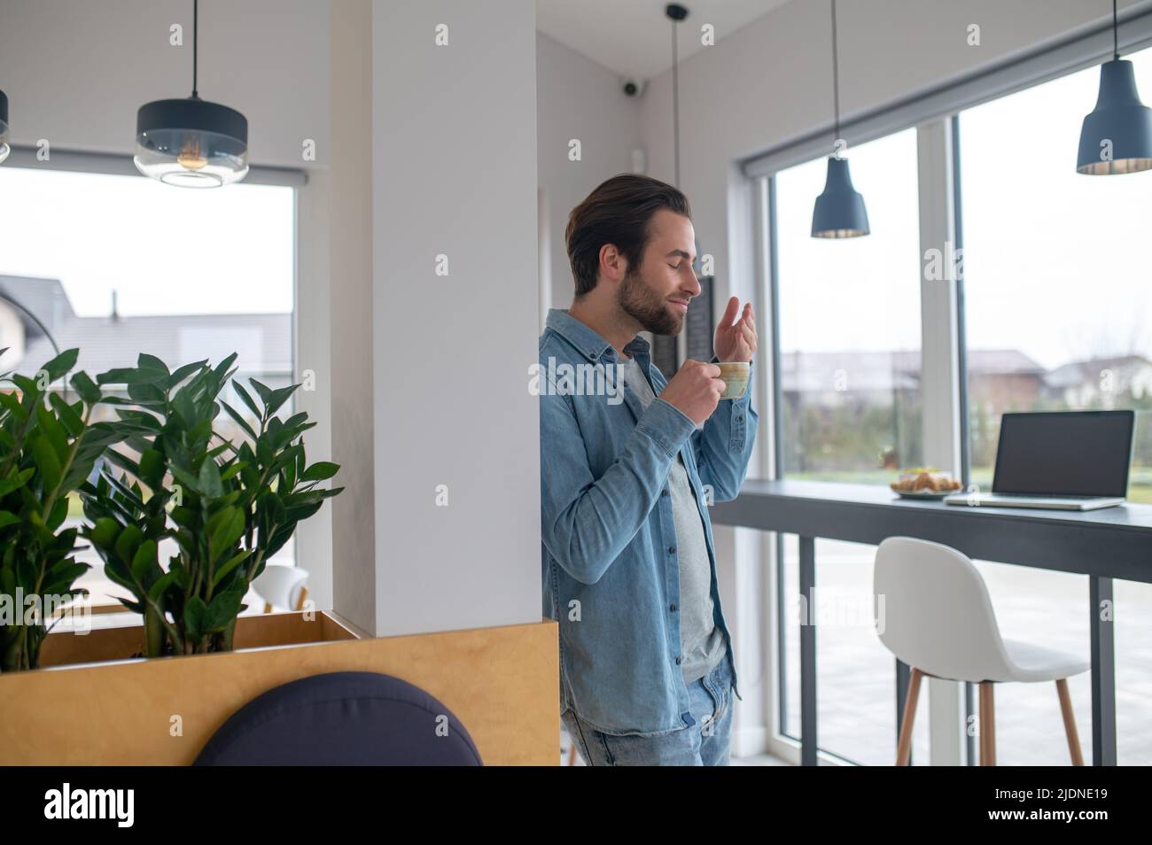 Man holding cup inhaling aroma of coffee Stock Photo