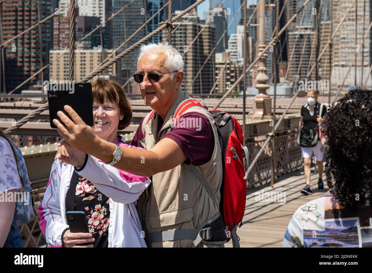 Elderly couple taking selfie on Brooklyn Bridge Pedestrian Walkway in New York City, United States of America Stock Photo