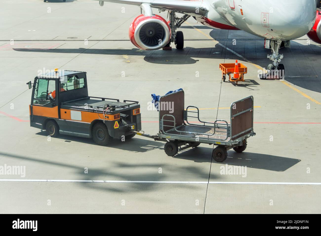 Special car and empty baggage cart next to the plane Stock Photo Alamy