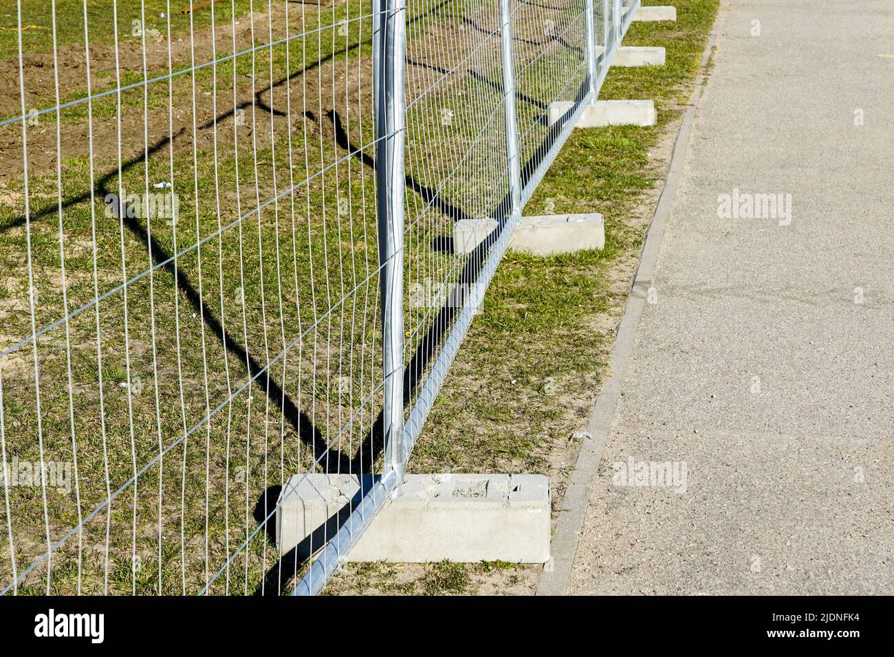 Temporary metal portable fence with concrete base blocks with holes for