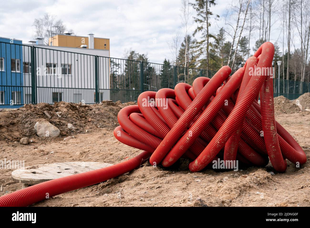 rolled up red corrugated PVC pipe for laying electrical cables Stock Photo