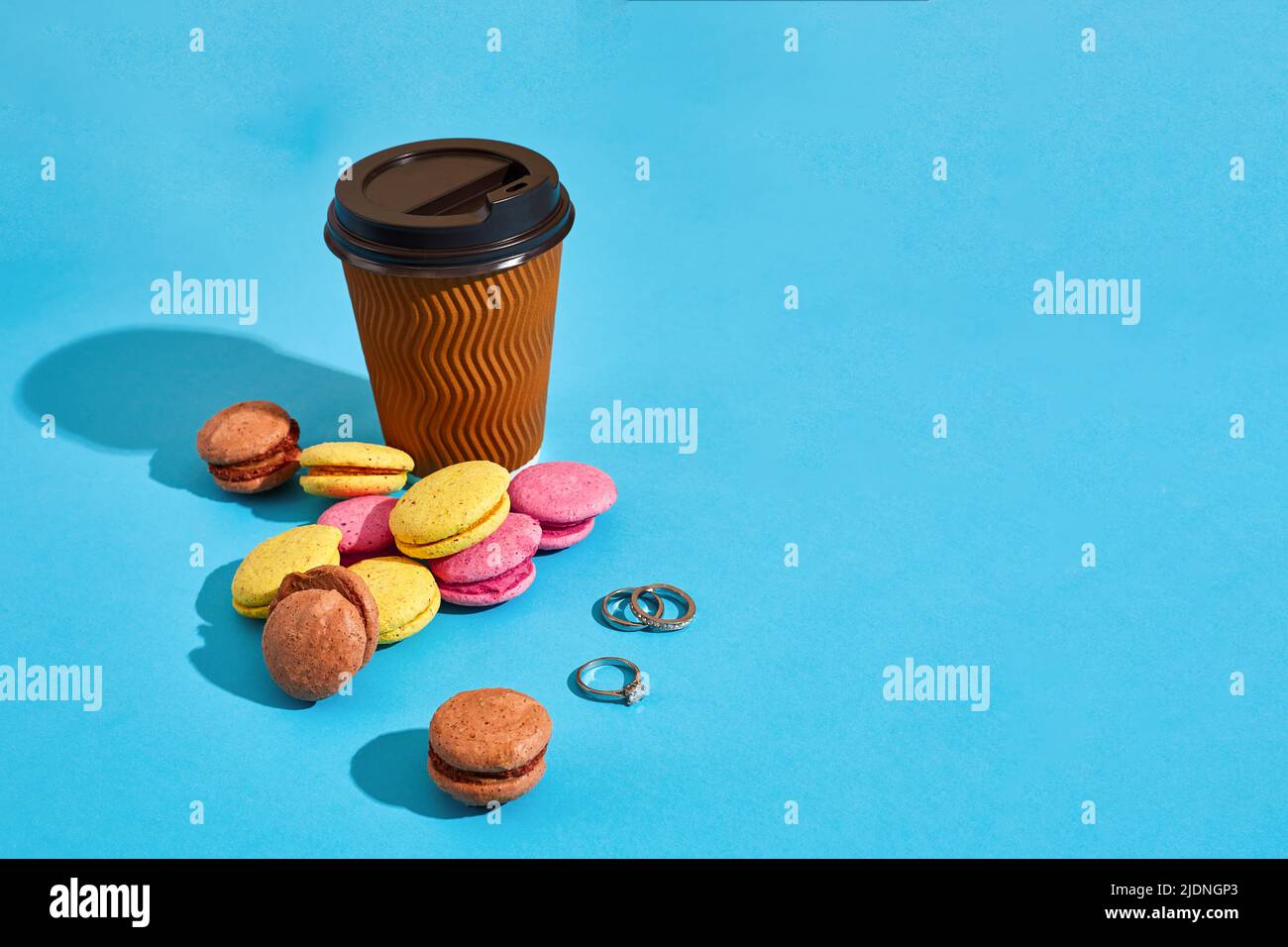 Hot coffee in brown paper cup with black lid and macaroons on bl Stock ...