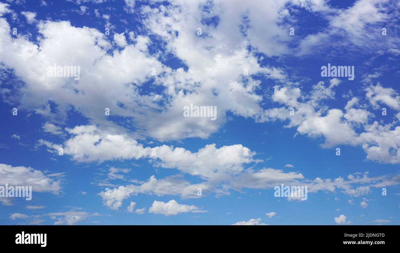 Puffy clouds against a sunny blue sky. Stock Photo