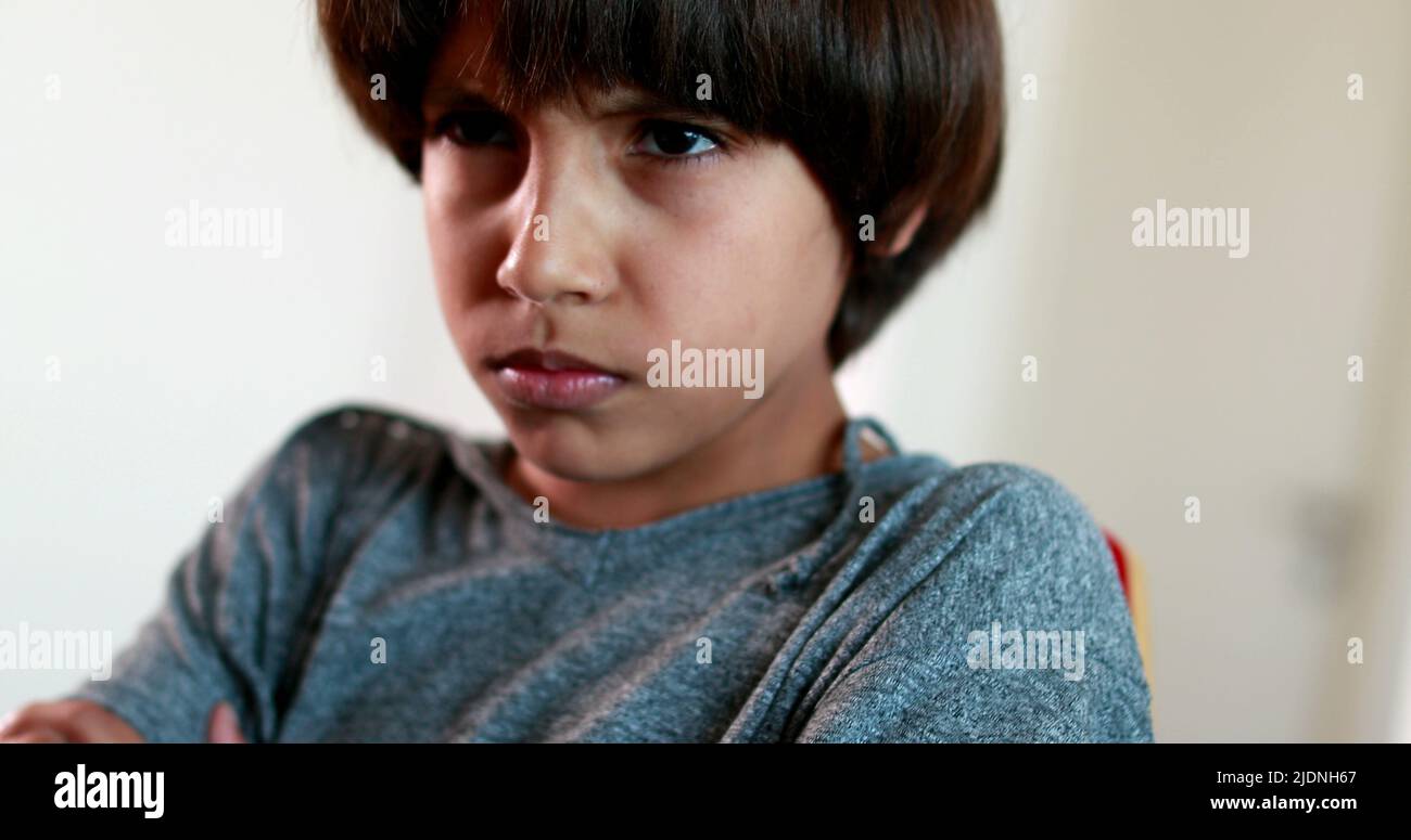 Angry child reaction crossing arms in anger. Offended young boy with
