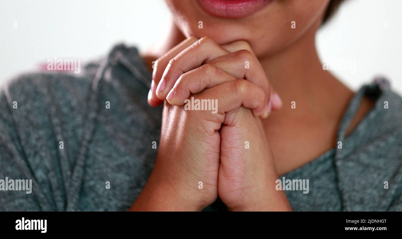 Boy praying to God with hands held together. Mixed race child prays  spiritually with eyes closed Stock Photo - Alamy
