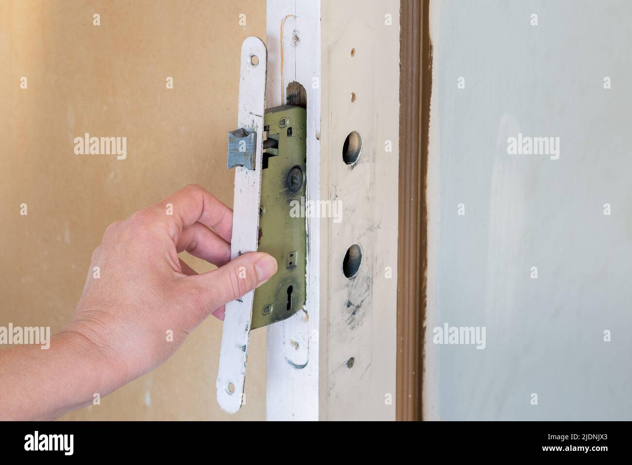 Interior renovation. Replacement of a door lock and handle Stock Photo